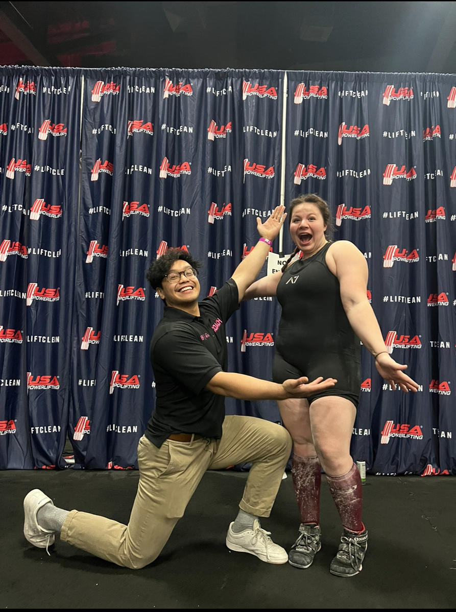 The coach is posing at USA Power Lifting.